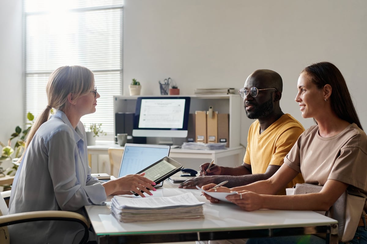 Notary consulting with clients at a table, reviewing documents together